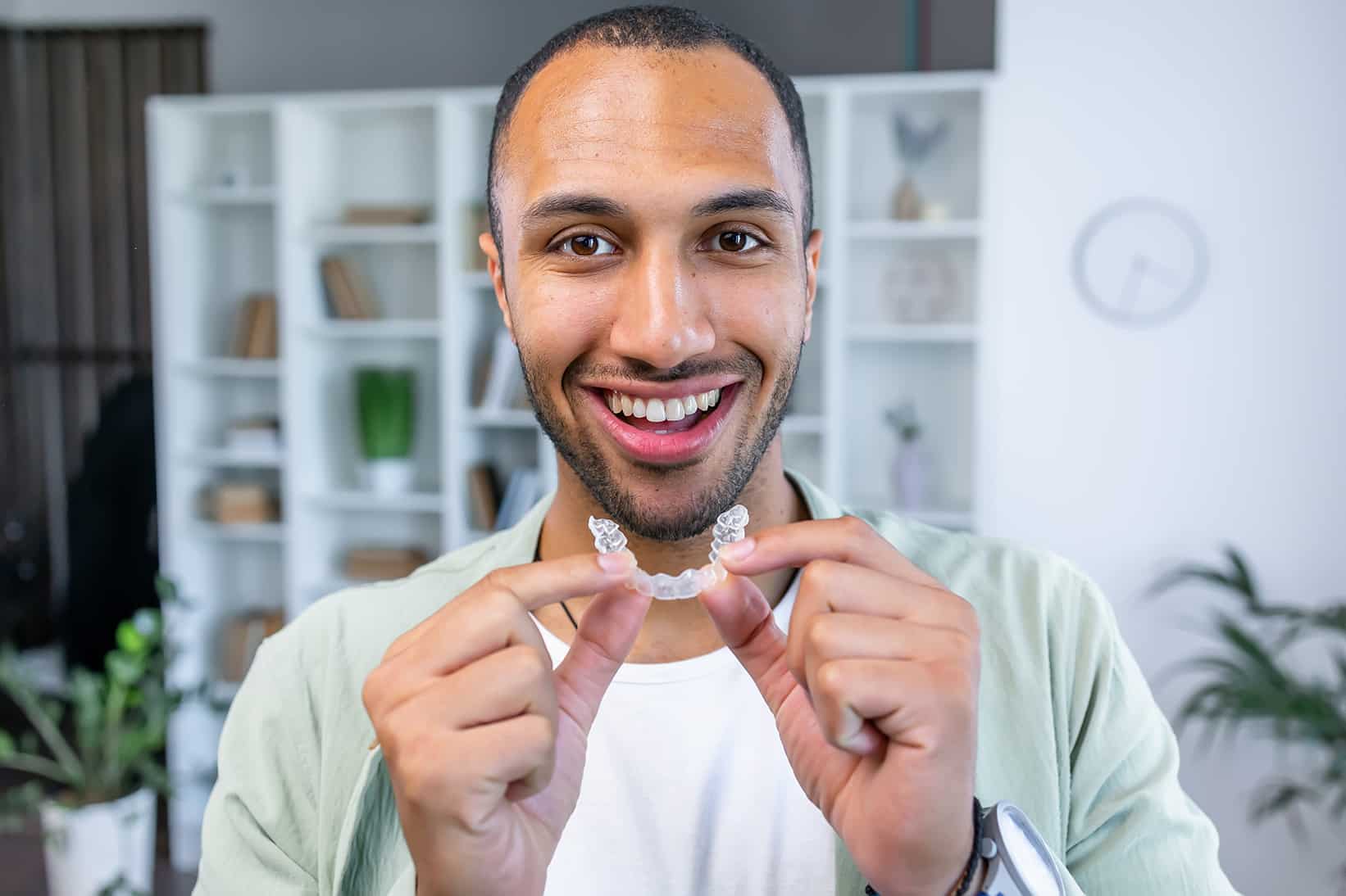 man placing invisalign clear aligners in his teeth from murphey dental aesthetics
