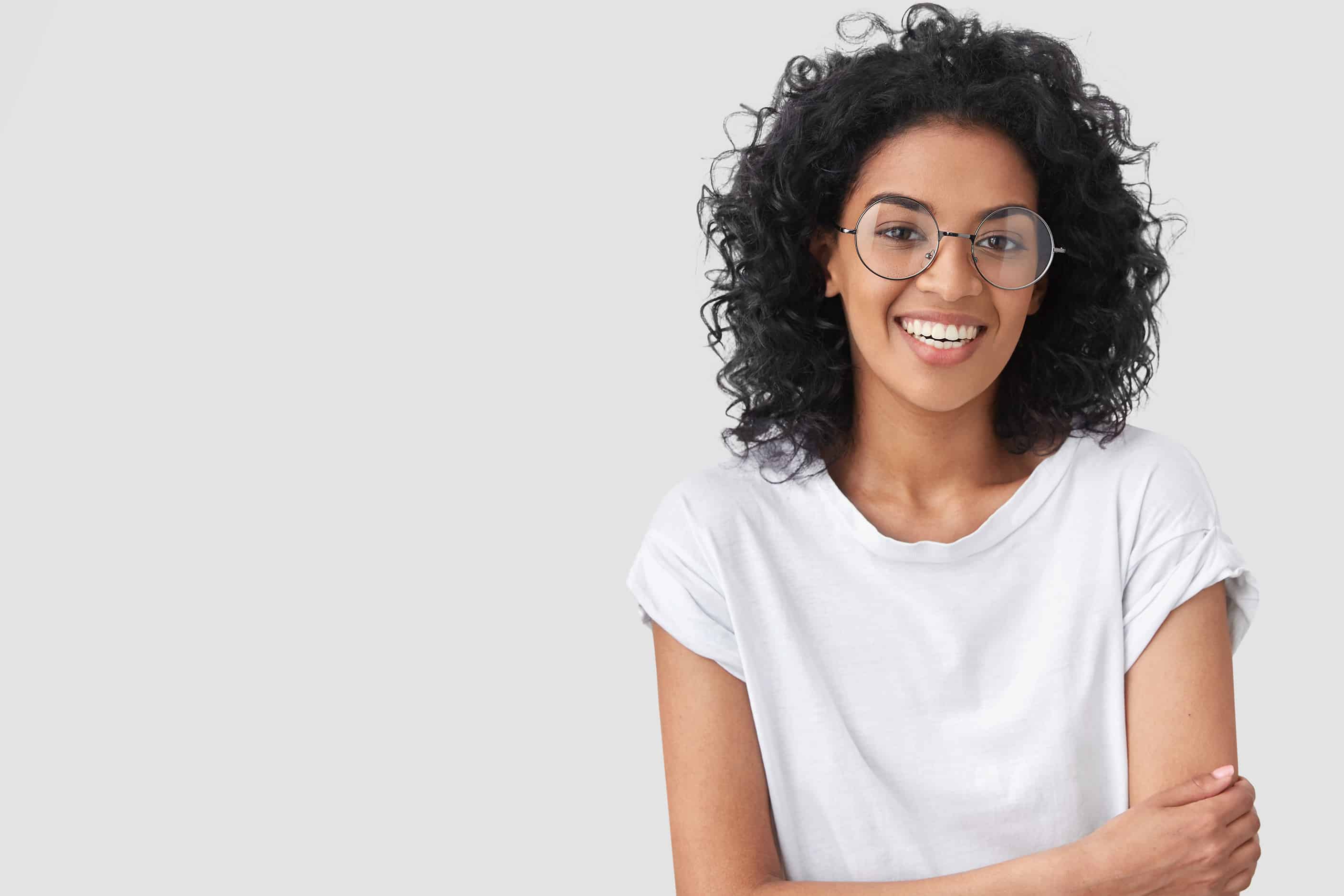 woman with glasses and arms crossed smiling - Murphey Dental Aesthetics