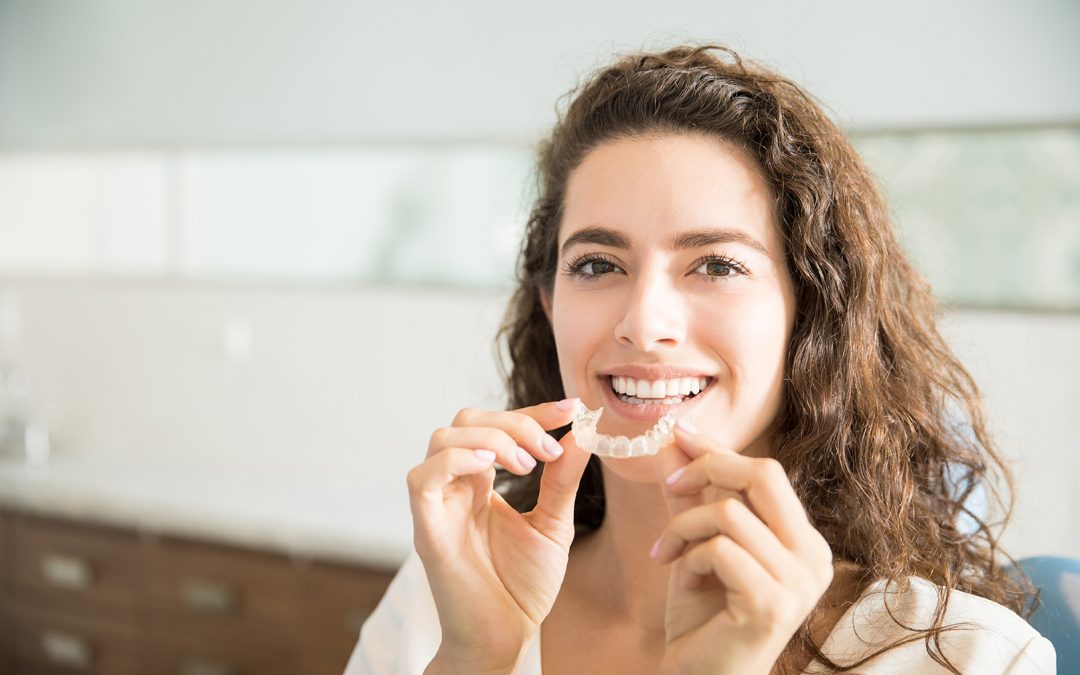 woman holding clear dental aligners from murpey dental aesthetics